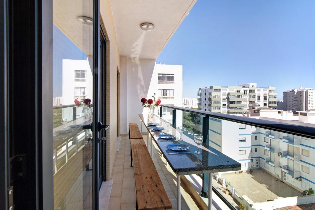 a balcony with benches and a view of a city at Quarteira Beach I in Quarteira