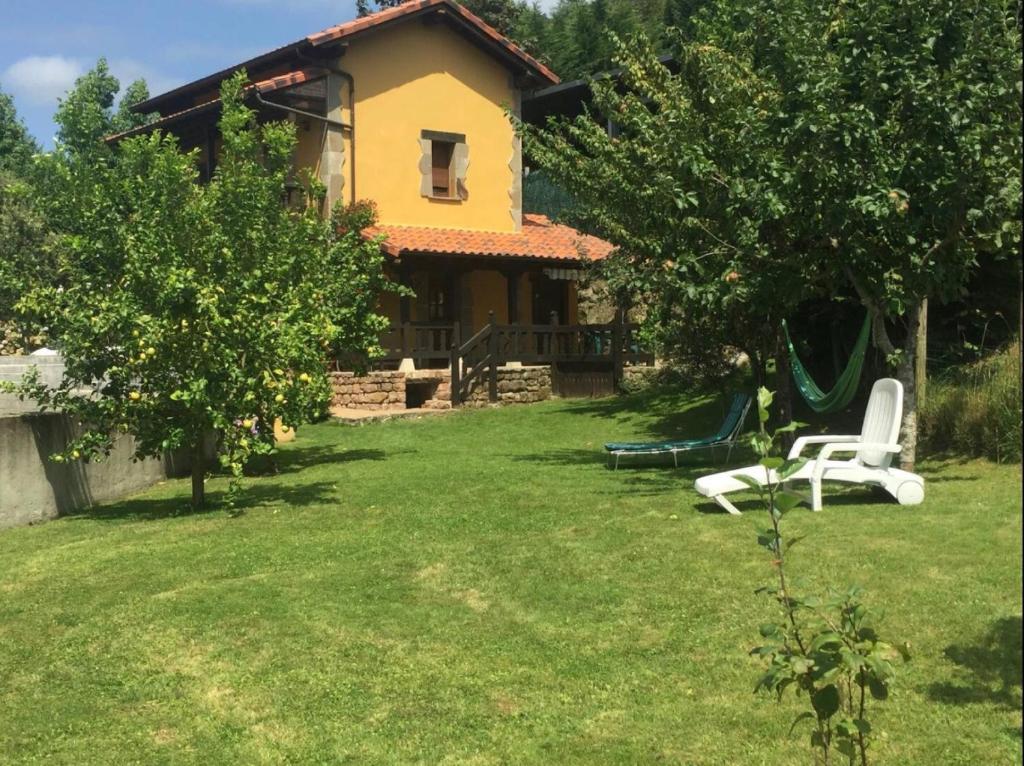 a house with a yard with a swing at Los Avellanos Casa 3 in Celis