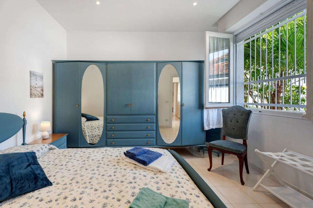 a blue bedroom with a bed and two mirrors at Casa Lago Leo in Omegna
