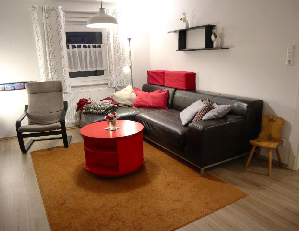 a living room with a black couch and a red table at Ferienwohnung im Haus Schwedes in Titisee-Neustadt