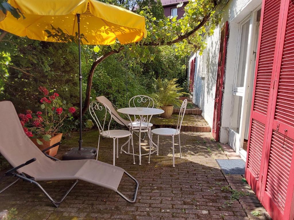 a table and chairs under an umbrella on a patio at Ferienwohnung Cipolla in Oberkirch