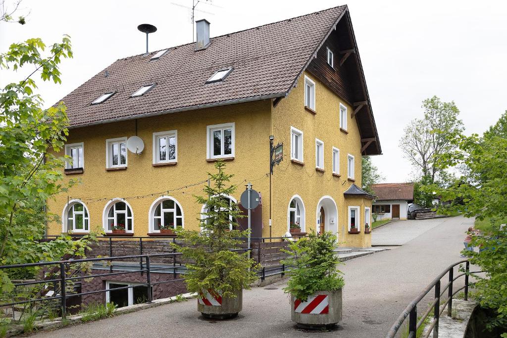 a large yellow building with a black roof at Kraichgauer Haus in Oberreute