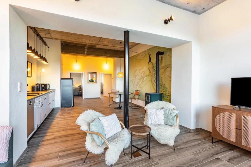 a kitchen and living room with white walls and wooden floors at Suiten im Alten Berghotel Antonia in Eslohe