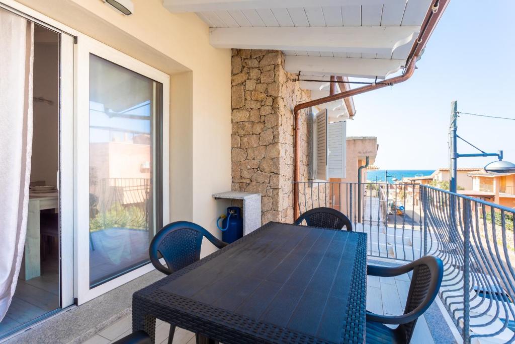 a table and chairs on the balcony of a house at Casa Macis vista mare in Isola Rossa