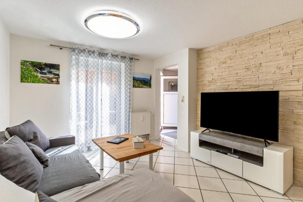 a living room with a large flat screen tv at Ribeiro Tesouro in Friesenheim
