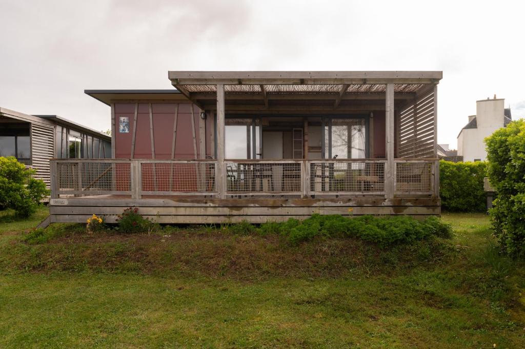a small house with a porch on a yard at Chalet 35m2 - Armen in Plouhinec