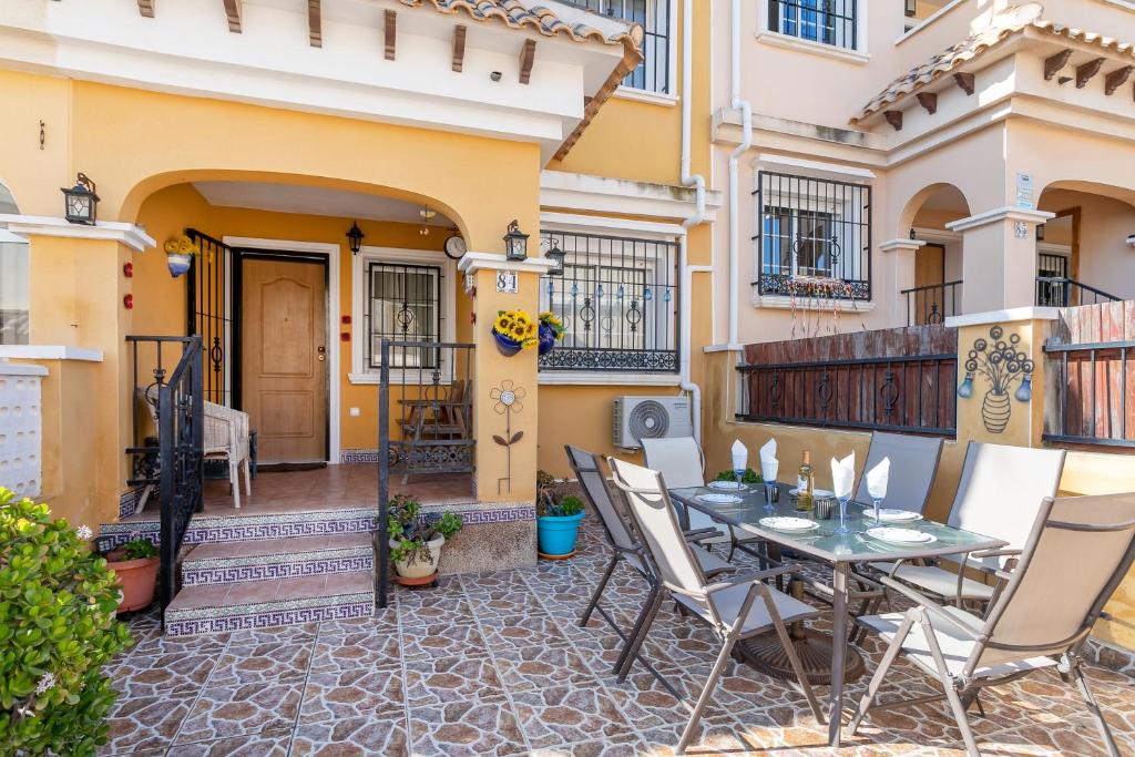 a patio with a table and chairs in front of a building at Casa Susan in Torrevieja