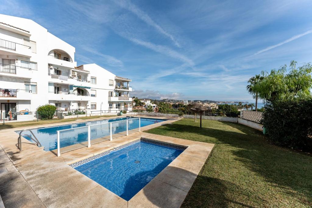 a swimming pool in a yard next to a building at Superbly situated Vistamar in Mijas Costa