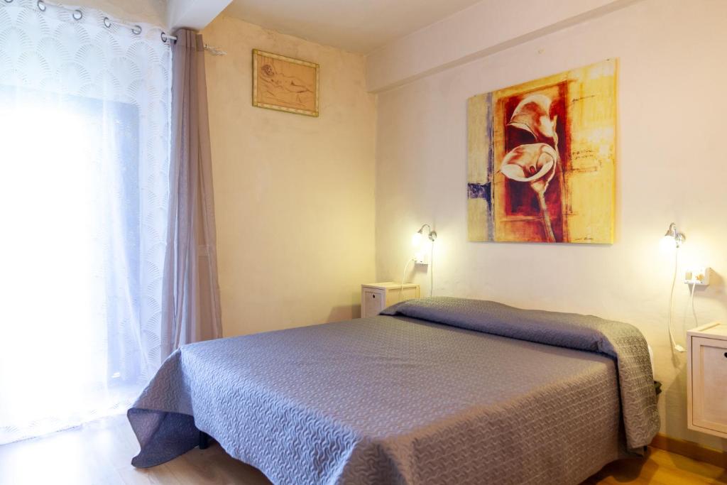 a bedroom with a bed and a painting on the wall at Appartamento il corso in Roccastrada