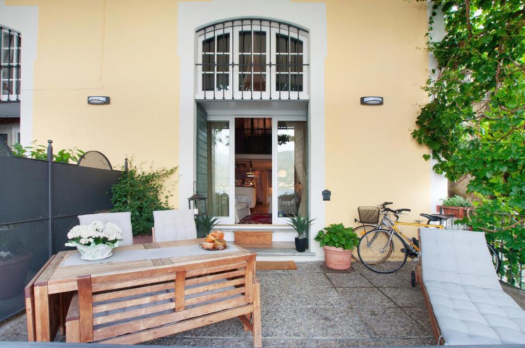 a patio with a wooden table and a bench at Casa Al Molo in Musso