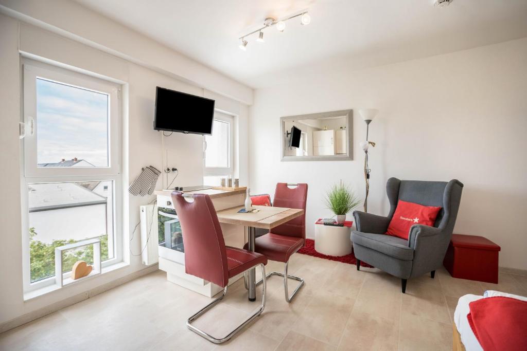 a living room with a table and chairs and a television at Ferienwohnung Seestern in Norderney
