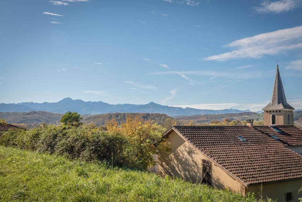 a small church with a steeple on a hill at Gites les Renardiers in Peyraube