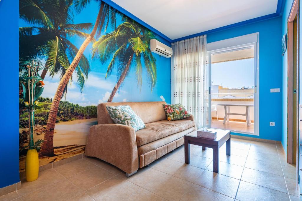 a living room with a couch and a palm tree mural at Neptuno in Oropesa del Mar
