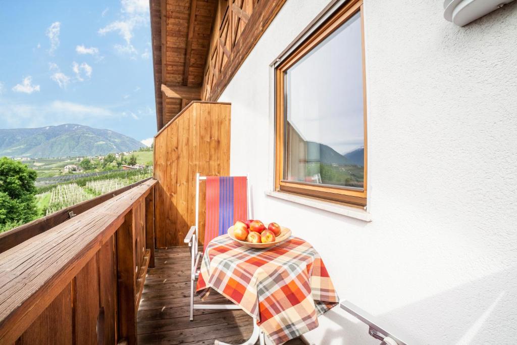 a table on a balcony with a bowl of fruit on it at Langeshof Fewo Löwenzahn in Caines