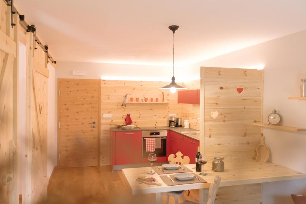 a kitchen with a wooden wall and a table at Ferienwohnung Wold Wieserhof in Aldino