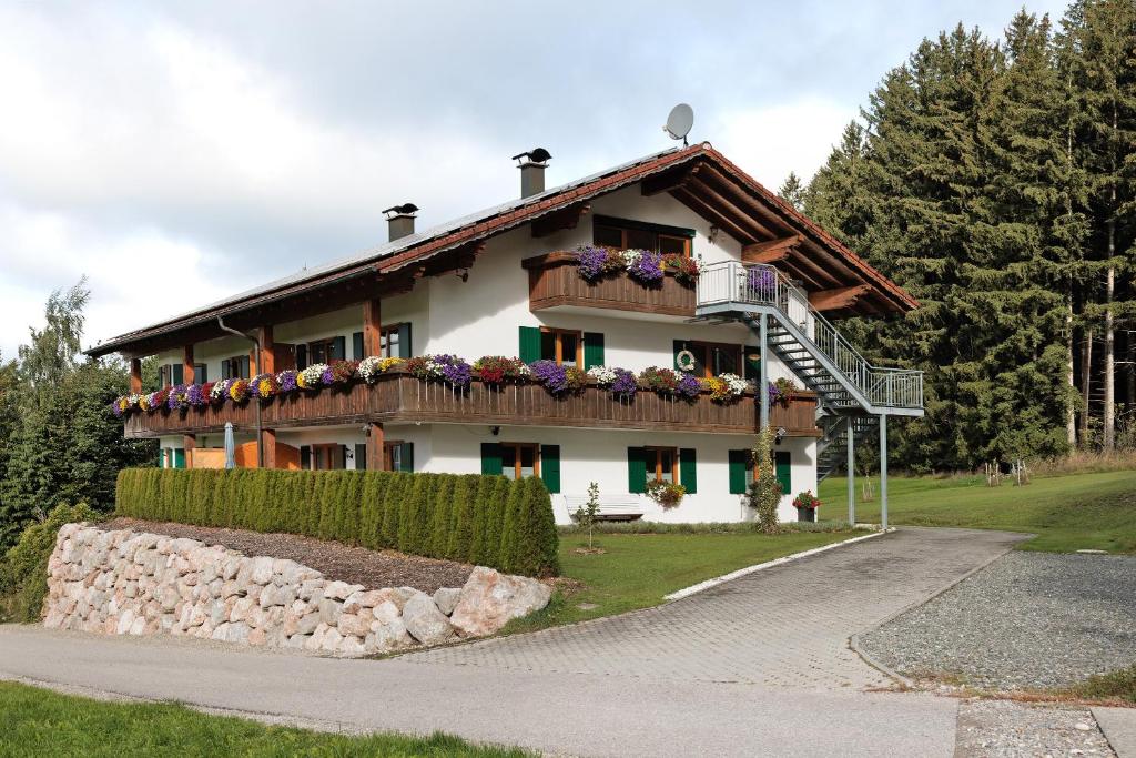 a house with a balcony with flowers on it at Martin´s Alm in Friesenried