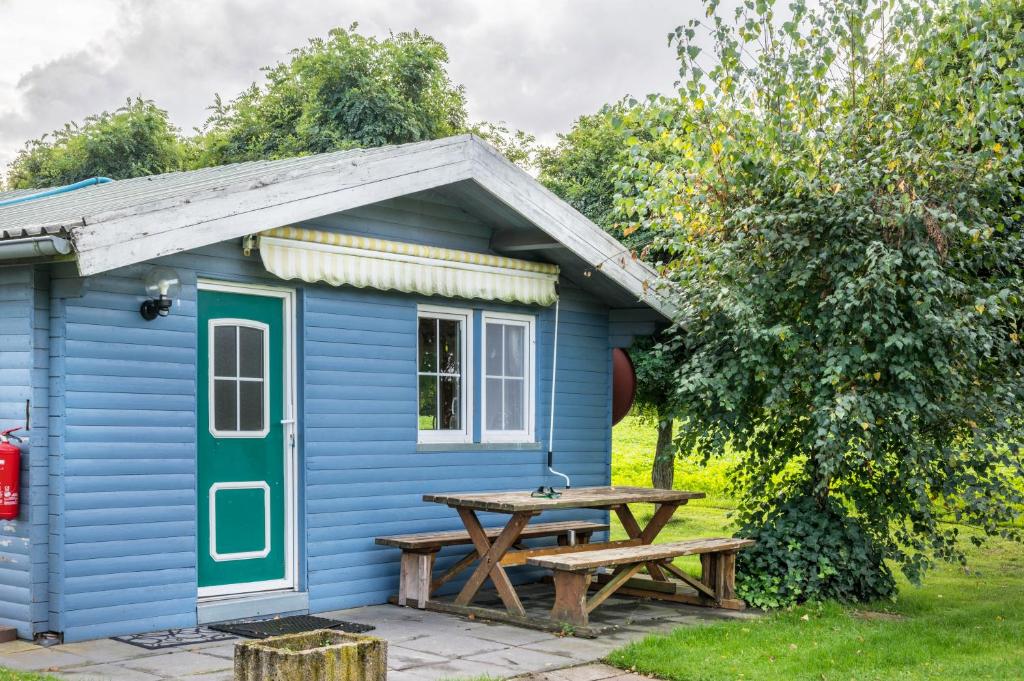 a blue shed with a picnic table in front of it at Kleines Gästehaus in Sudwalde