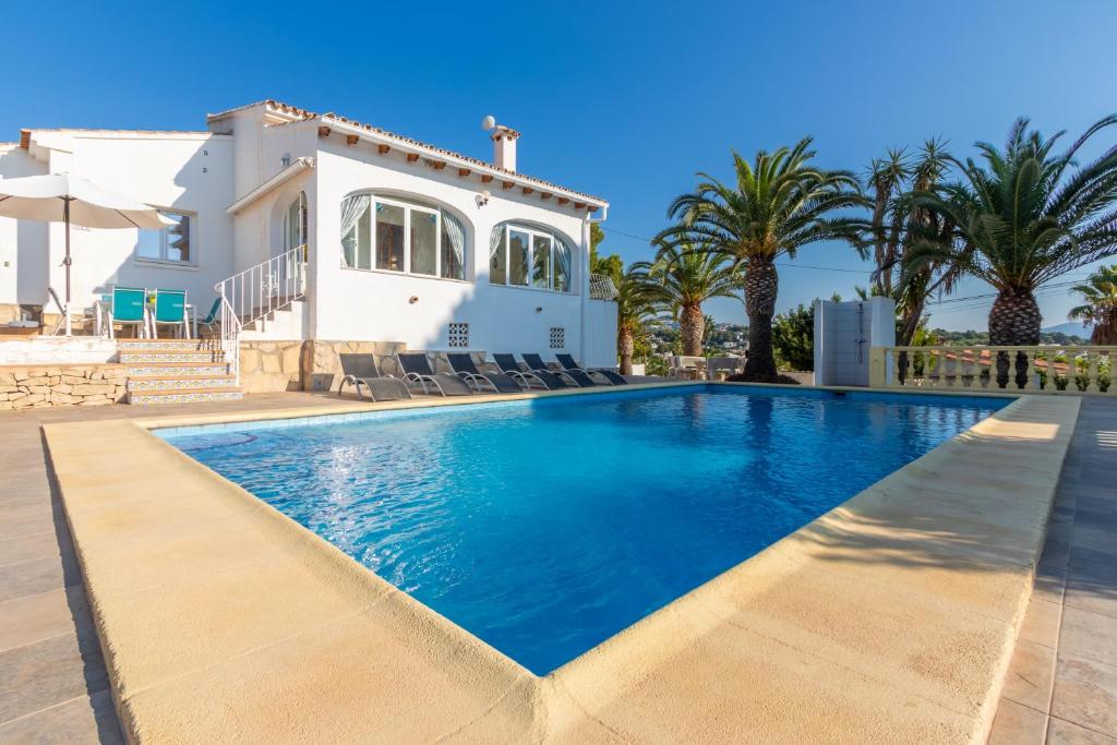 a villa with a swimming pool in front of a house at Villa Rosa in Benissa