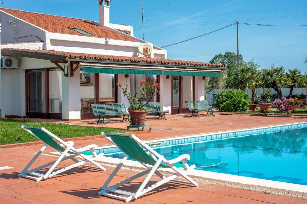 a pair of lawn chairs next to a swimming pool at Villa Sole Pula in Pula