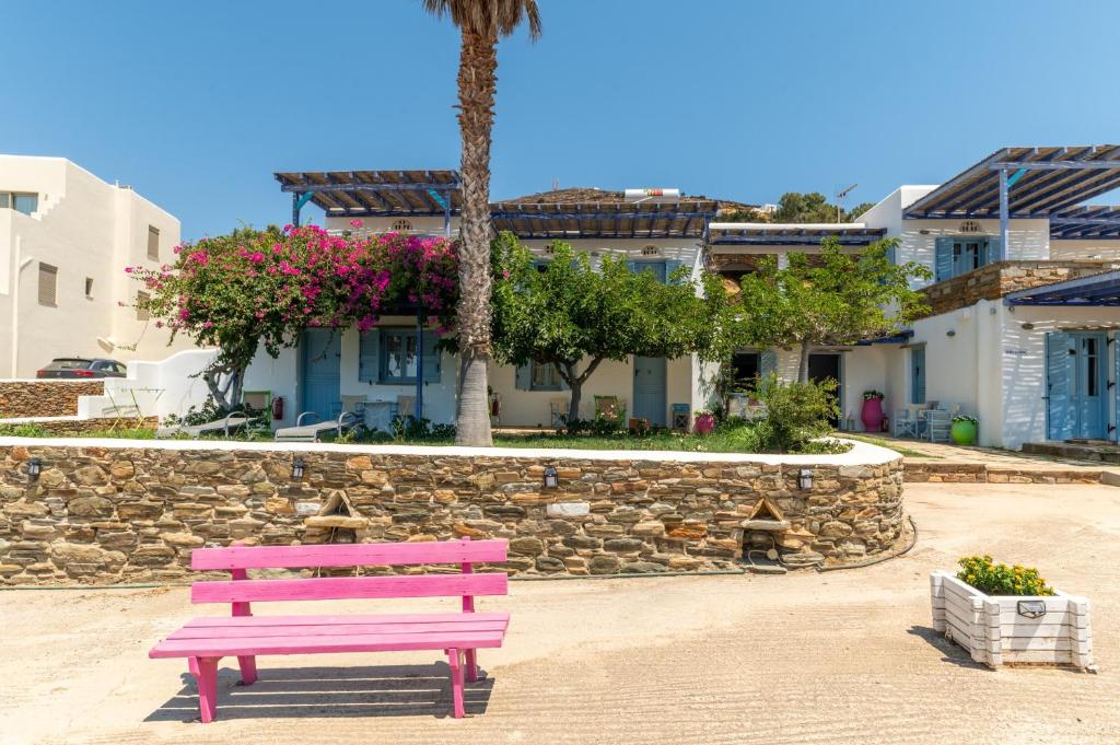 a pink bench sitting in front of a stone wall at La Casa Tinos 22 in Tinos
