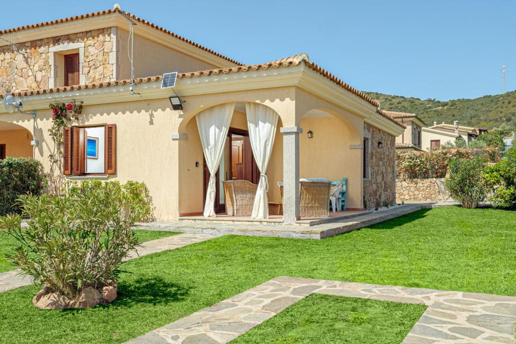a house with a green yard with a patio at New Villa Carmen in San Teodoro