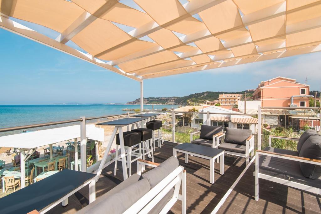 a balcony with tables and chairs and the ocean at Mirage Arillas Studio Type A4 in Arillas
