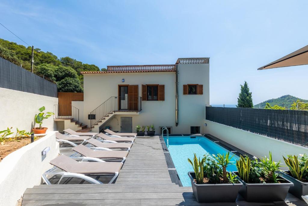 a villa with a swimming pool and lounge chairs at Sestel in Capdepera