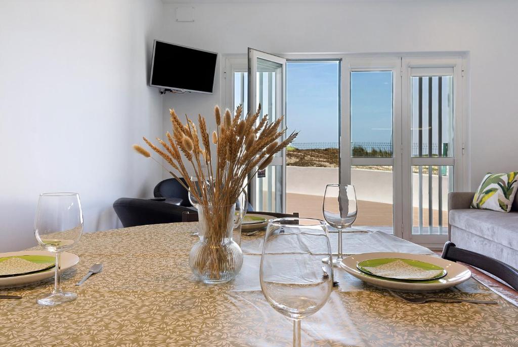 a table with glasses and a vase of flowers on it at Casa Vasconcelos in Afife