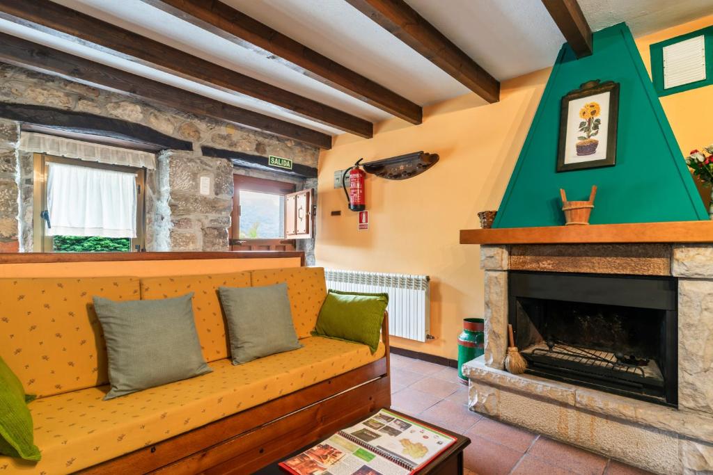 a living room with a couch and a fireplace at Lorences D in Caunedo