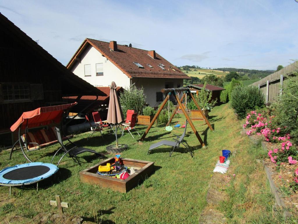 a backyard with a swing set and a playground at Ferienwohnung Geistalblick in Neuenstein