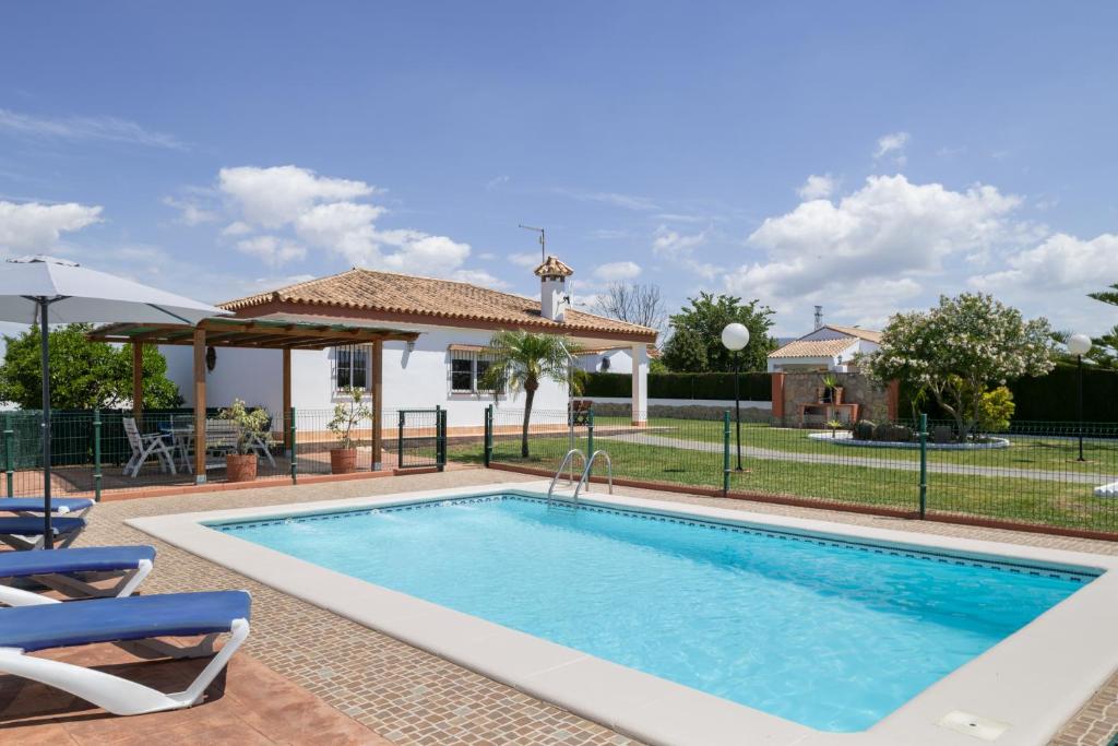a swimming pool in front of a house at Casa Alfonso Manuel in Roche