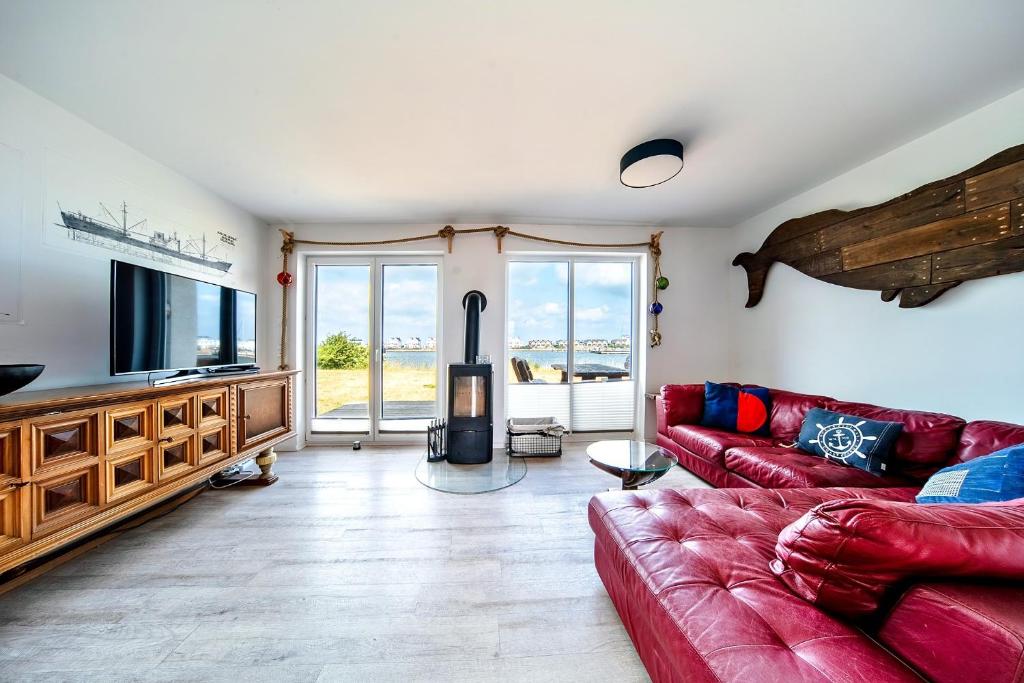 a living room with a red couch and a fireplace at Boje by Seeblick ferien oro in Kappeln