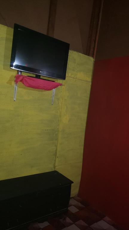 a room with yellow and green walls and a tv on the wall at rushels in Drunkenmans Cay