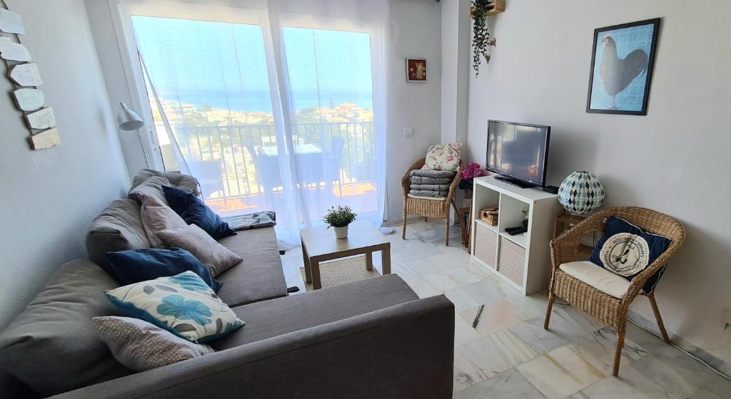 a living room with a couch and a television at La Cala Apartment in La Cala de Mijas