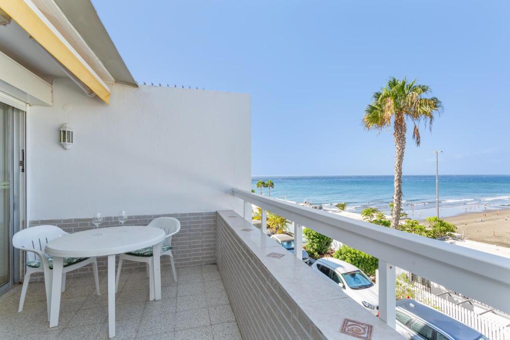a balcony with a table and chairs and the beach at Al Mar en San Agustín in San Bartolomé
