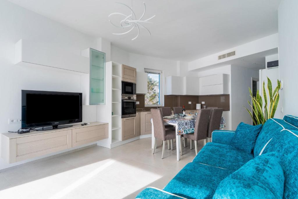 a living room with a blue couch and a dining room at Suite Buena Vista in Gallipoli
