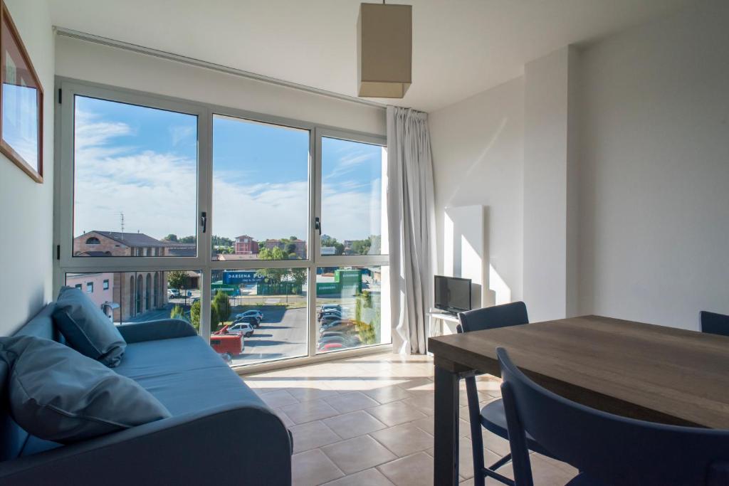 - un salon avec un canapé bleu et une grande fenêtre dans l'établissement Darsena Ravenna Apartments, à Ravenne