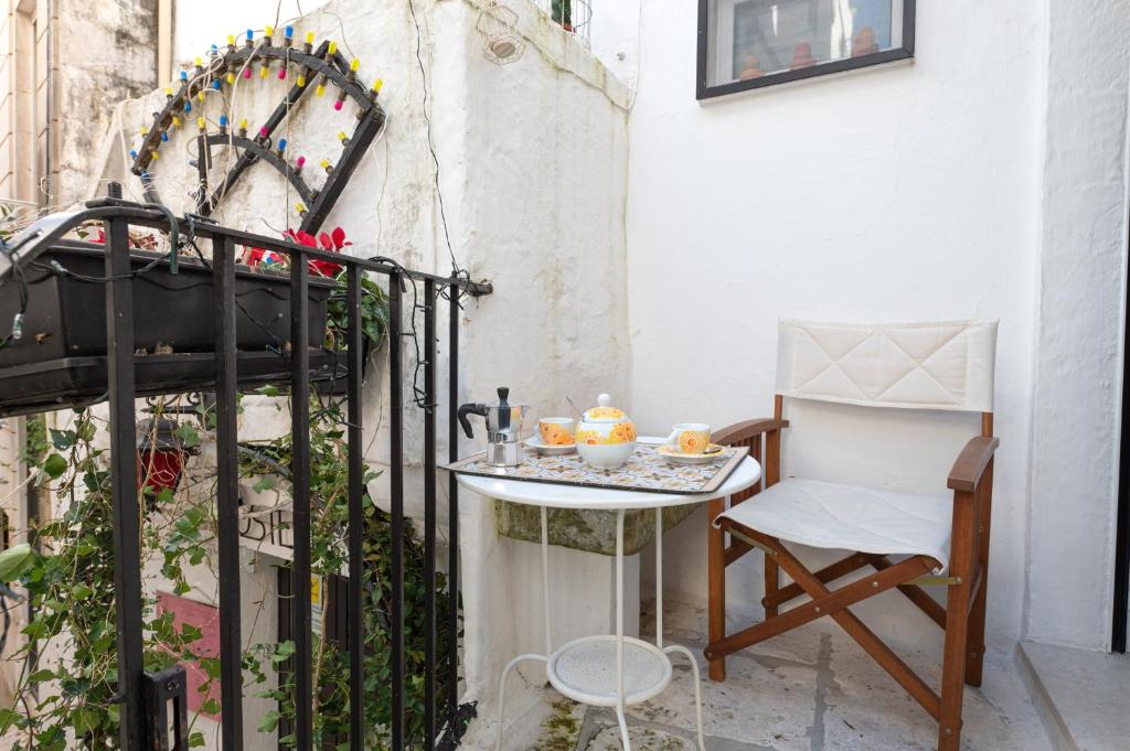 a small table and a chair on a balcony at Casa Agata Cisternino in Cisternino