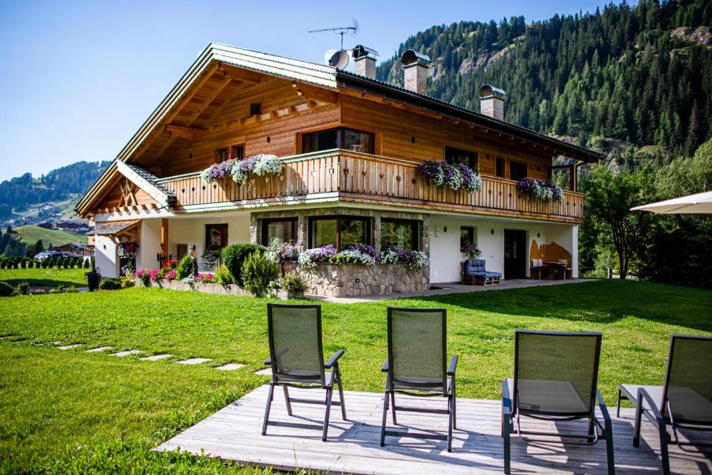 a house with chairs sitting in front of it at Piciulei Pitl in Selva di Val Gardena