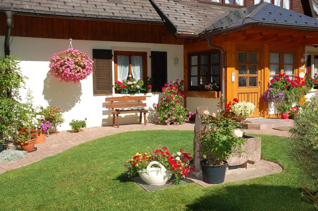 a garden with flowers and a bench in front of a house at Haus Scherer in Sankt Peter