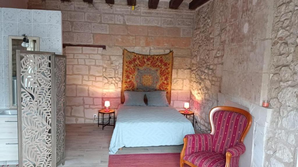 a bedroom with a bed and two chairs at Chambre Hirondelle in L'Ile-Bouchard