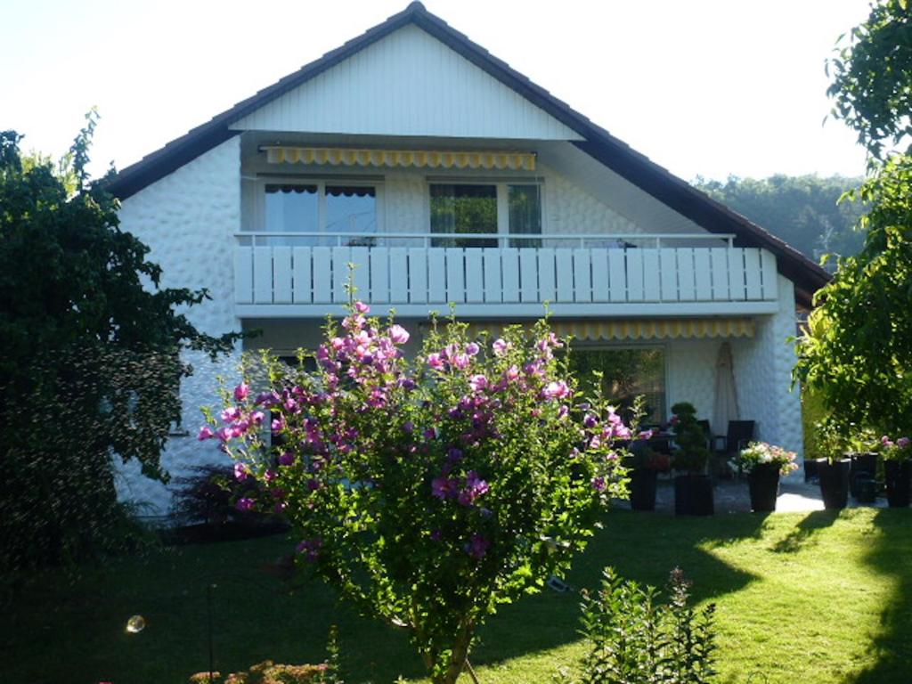 a white house with a balcony and flowers at Ferienwohnung Lumafe in Überlingen
