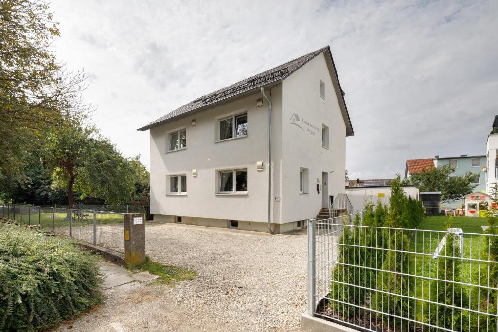a white house with a fence in front of it at Ferienwohnung Bailey in Laupheim