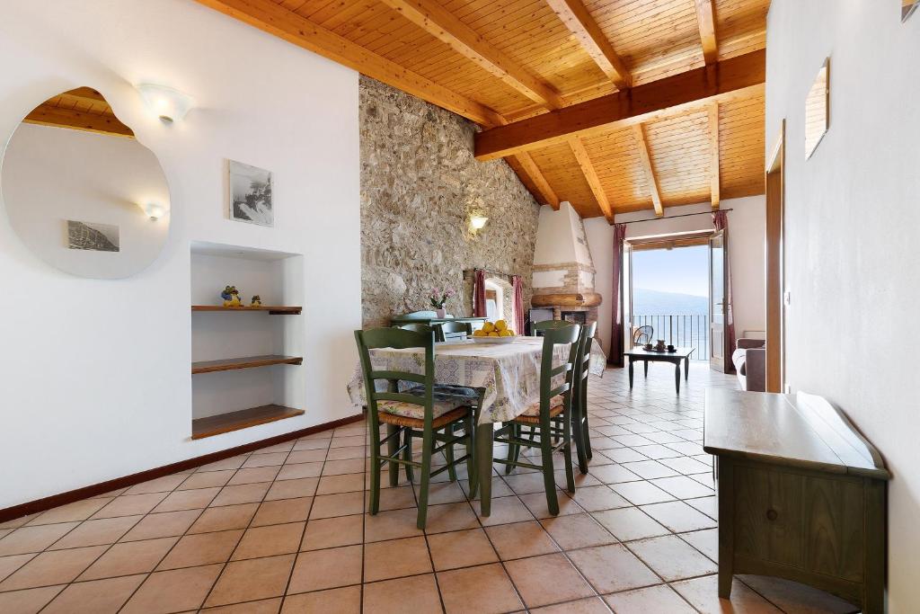 a kitchen and dining room with a table and chairs at Rustico Spagnol 4 in Tignale
