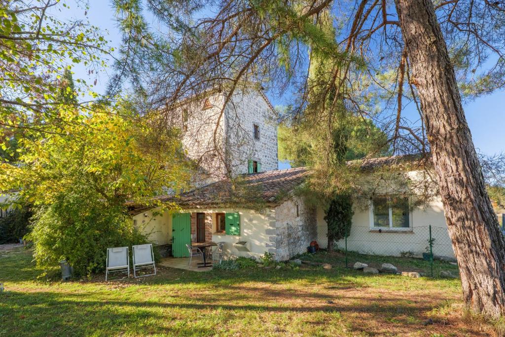 an old stone house with a green door at Chambre La Louve in Banne