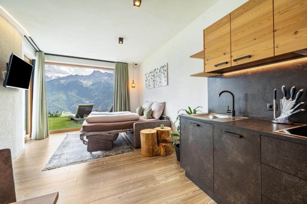 a kitchen and living room with a view of a mountain at Paflur Lodges Lärchenduft in Lasa