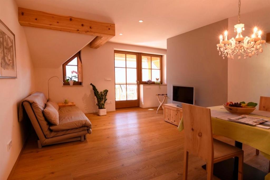 a living room with a dining room table and a chandelier at Rosengartnerhof Apt Gantkofel in Terlano