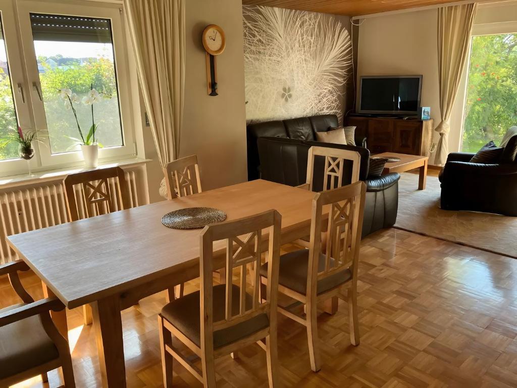 a dining room and living room with a table and chairs at Ferienwohnung Wartehof in Bad Emstal