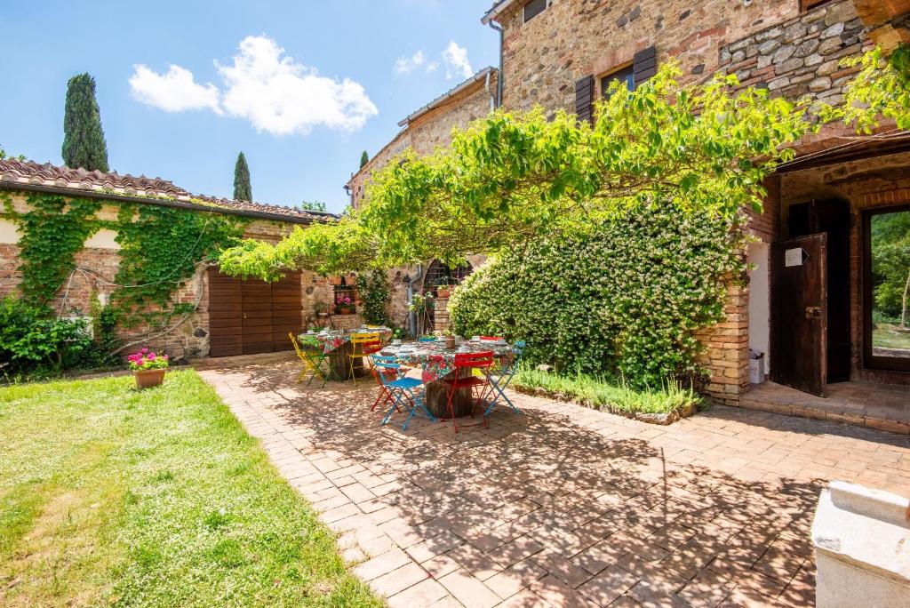 a patio with a table and chairs in a yard at Casa Alta Villa esclusiva in Murlo