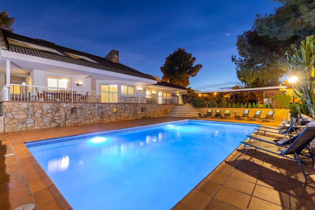 a swimming pool in front of a house at Fidalsa Paradise Pines in La Alcayna